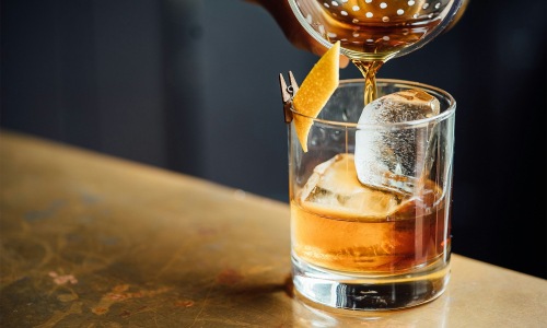 Settle into comfort at 610 West a glass of liquid being poured into a glass with ice