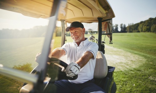 Close to the center of everything a man driving a golf cart