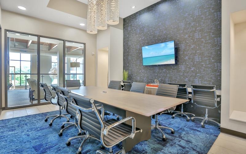 a conference room with a large table and a tv