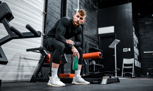 Settle into comfort at 610 West a person sitting on a bench in a weight room