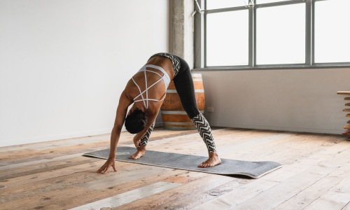 Cutting-edge amenities at your fingertips woman doing yoga in sun-filled studio
