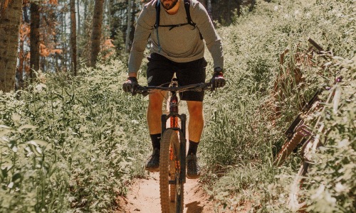 A beautiful community at the heart of all your passions man riding a bike on a trail in the woods
