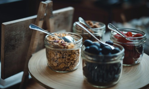 Vibrant community life with a variety of dining options granola and fruit filled jars with spoons on a table