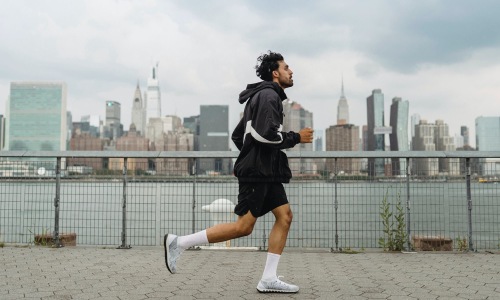 A perfect fit for the whole family a person running on a stone path with a city skyline in the background